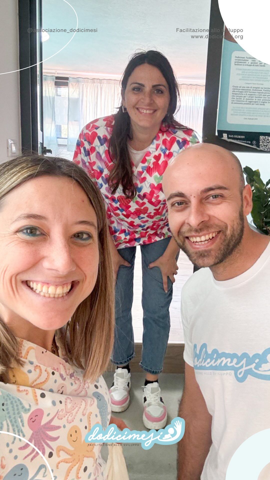 Un genitore tiene in braccio un neonato mentre parla con un’osteopata pediatrica in uno studio luminoso.